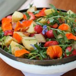 Photo of a potato salad with strawberries, bitter herbs and nasturtiums