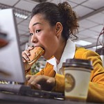 Photo of a woman eating at her desk