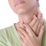 Photo of a woman holding a sore throat