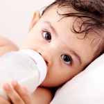 Photo of an infant drinking from a bottle