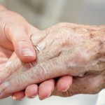 Photo of a young hand holding an older hand